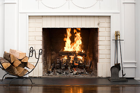 Home Inspector Keswick picute of a wood burning firplace with white brick border representing a fireplace that a home inspector would do a WETT inspection on